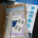 STOPM_2020_412b: The home-test kit contents including a swab in a packet, a sample pot, barcode stickers, a plastic sealable bag, and a security seal sticker.  Thumbnail