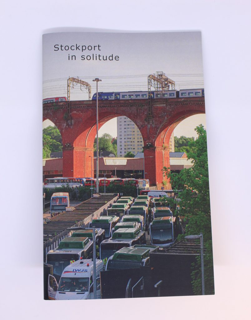 STOPM_2020_418a: A booklet; the front cover of the zine entitled 'Stockport in Solitude' by Jake Bowden. It features a photograph of a train going over the Stockport Viaduct, with Stockport bus station below, taken by Jake in 2020. 