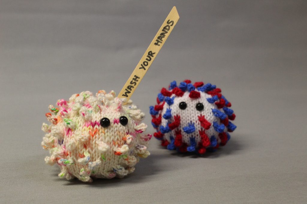 STOPM_2020_453b: both the knitted VE coronavirus and the 'Wash Your Hands' knitted coronavirus together in a photograph.
