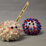STOPM_2020_453b: both the knitted VE coronavirus and the 'Wash Your Hands' knitted coronavirus together in a photograph. Thumbnail